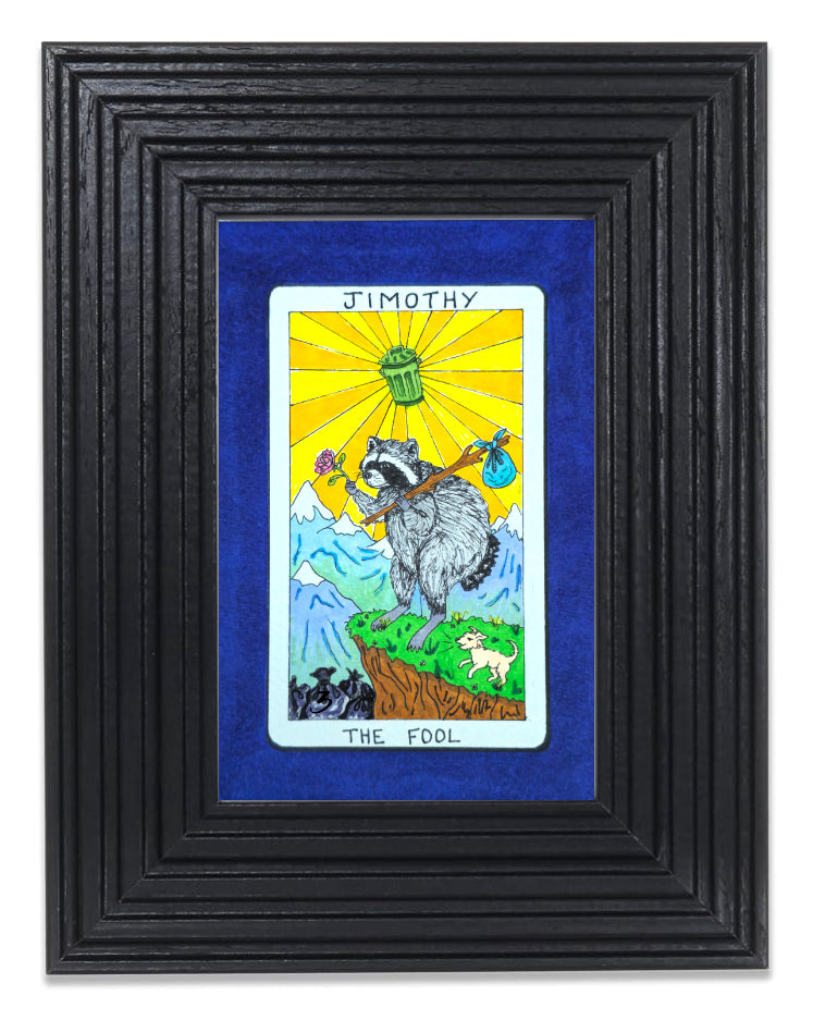 A framed art print featuring a tarot card illustration titled 'JIMOTHY THE FOOL' with a blue mat and a thick black textured frame.