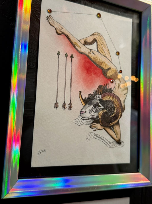 Framed art print featuring a tattoo-style illustration of a human figure draped over a ram, with red celestial lines and three arrows on a white background, set in a holographic iridescent frame.