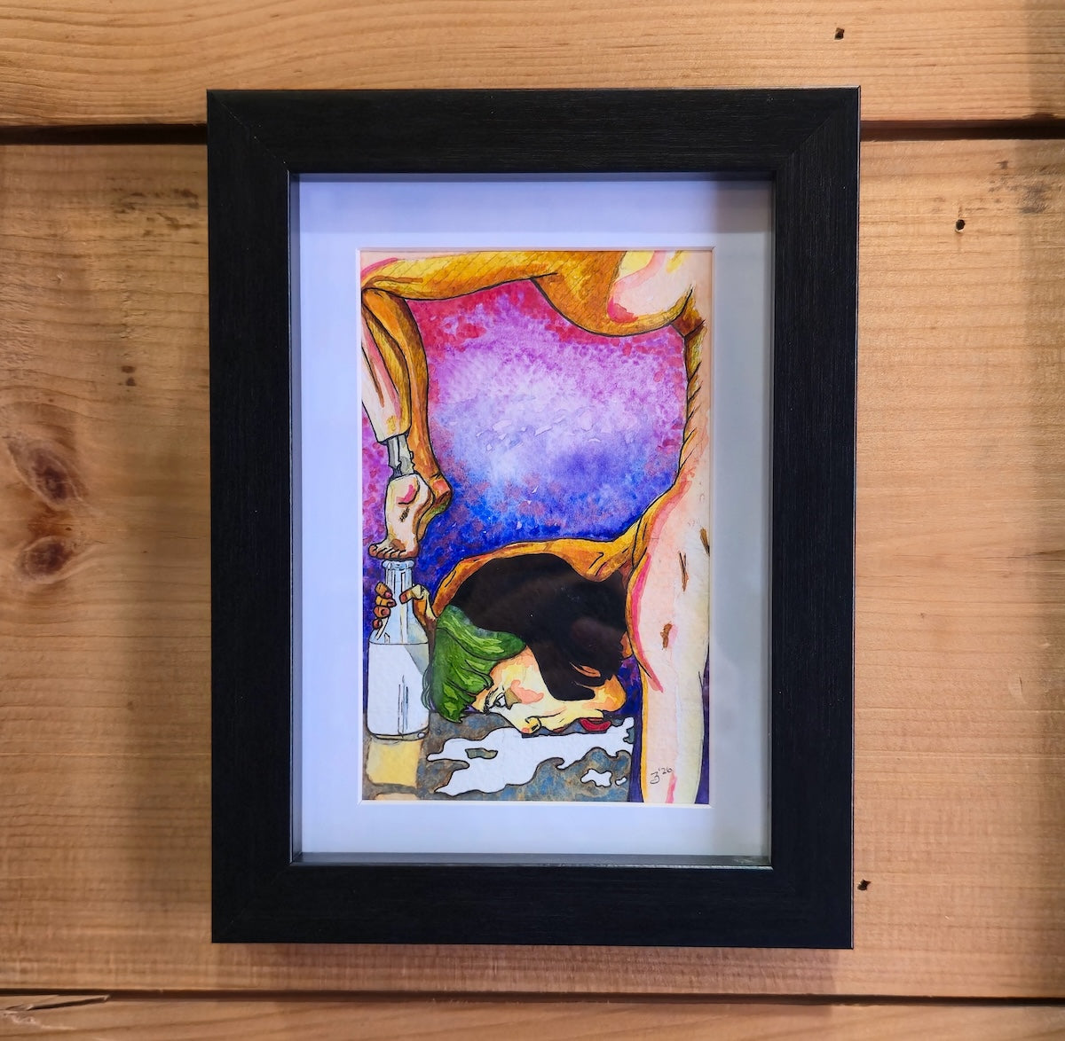 Framed artwork of a colorful abstract design on a wooden surface